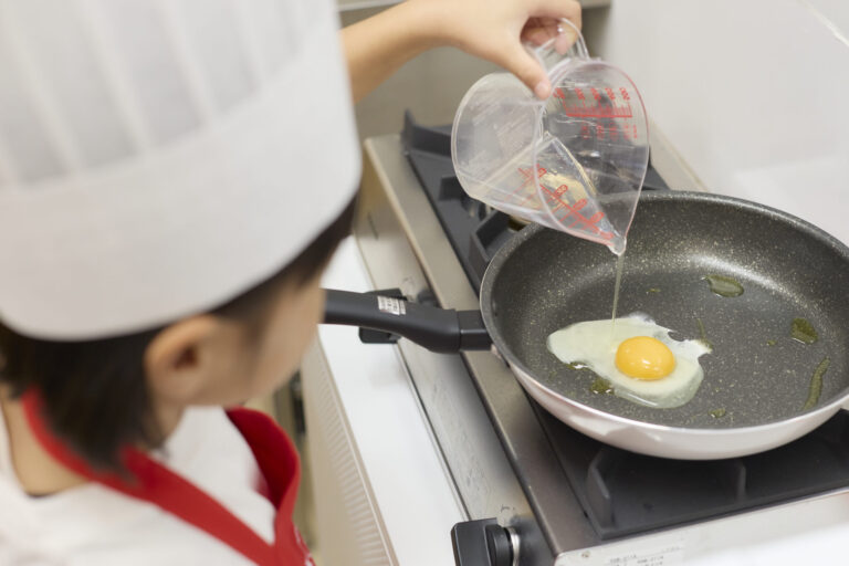 我孫子校で目玉焼きをつくる子ども