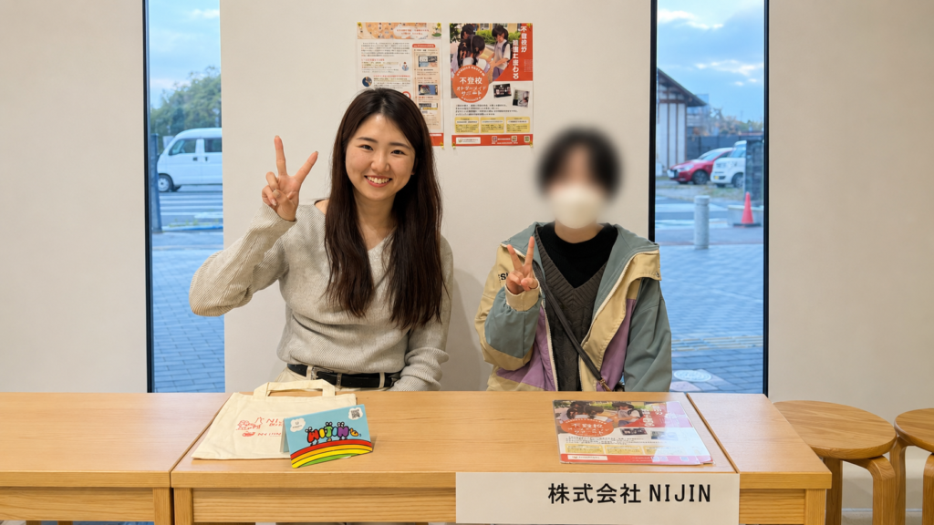 子どもと一緒にNIJINの案内ブースに立つあおたりさん