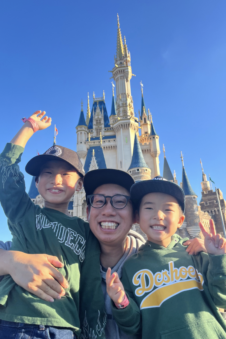 ディズニーランドで二人の息子と笑顔の市川芳彦さん