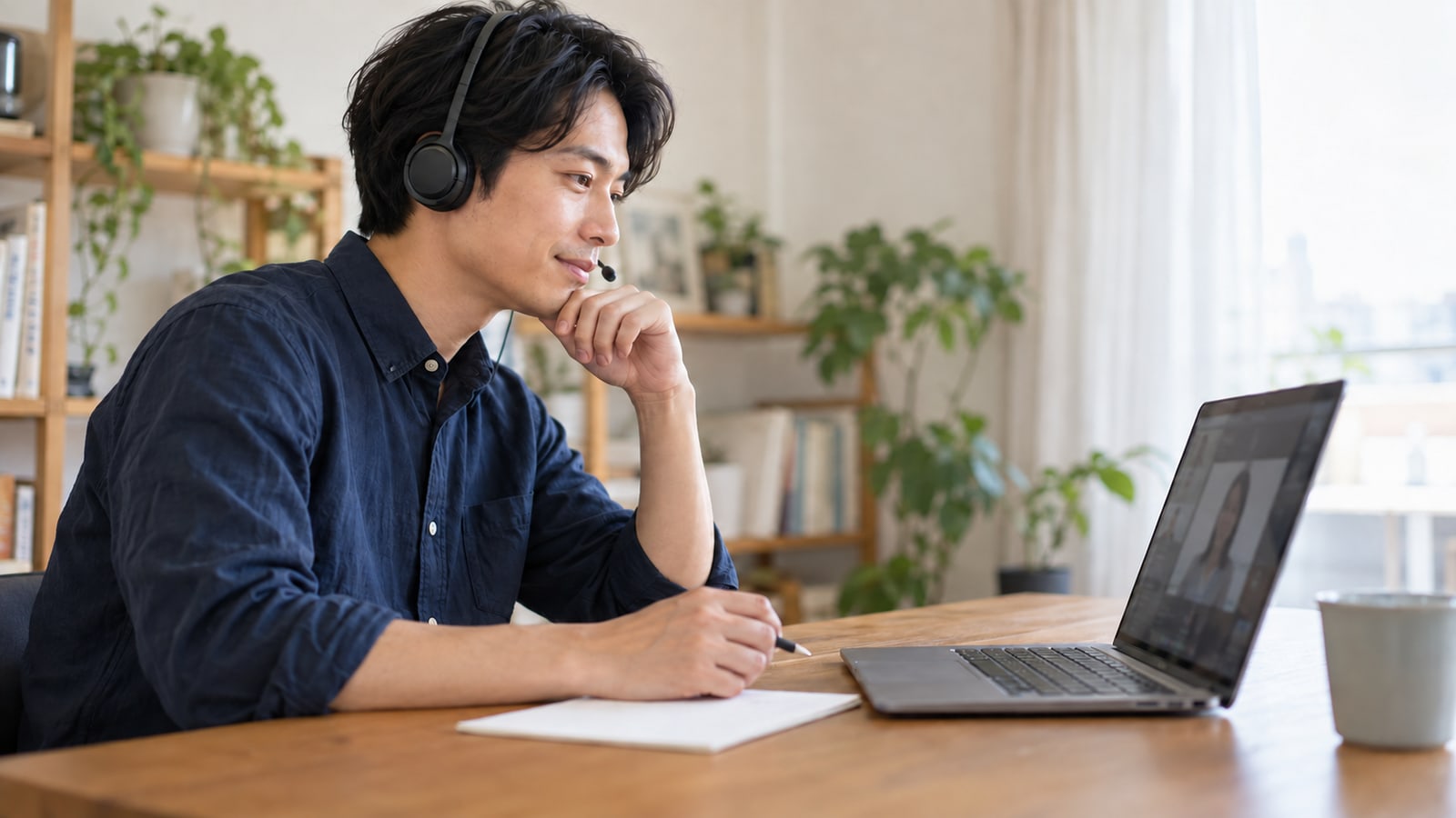個人のパソコンでオンラインの仕事説明に耳を傾ける男性