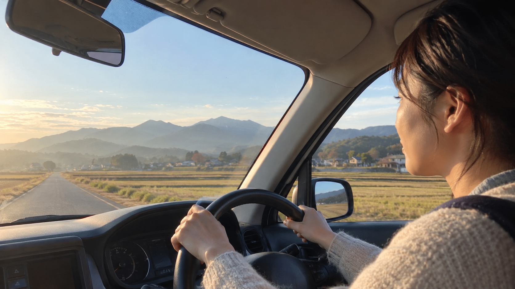 福島の教員が朝、田園の道を車で学校へ向かう30代の先生（イメージ）