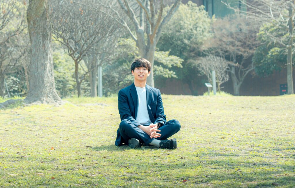 森川陸さんの公開インタビューに掲載された、芝生に座る姿の写真