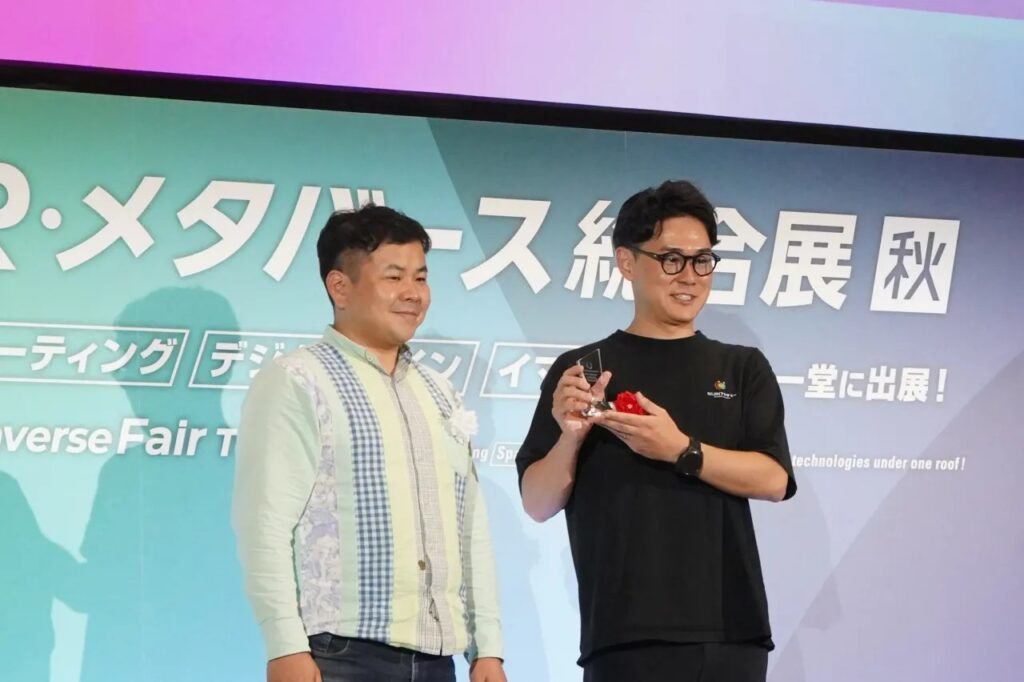 Japan Metaverse Awards 2025 ソーシャルイノベーション賞のトロフィーを受け取る株式会社NIJIN代表・星野達郎（メタバースの不登校支援NIJINアカデミー）