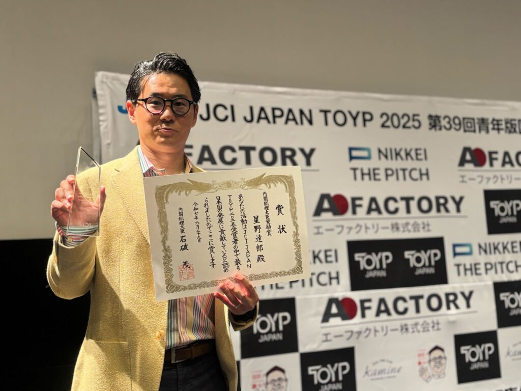 青年版国民栄誉賞の賞状と表彰盾を持つ星野達郎